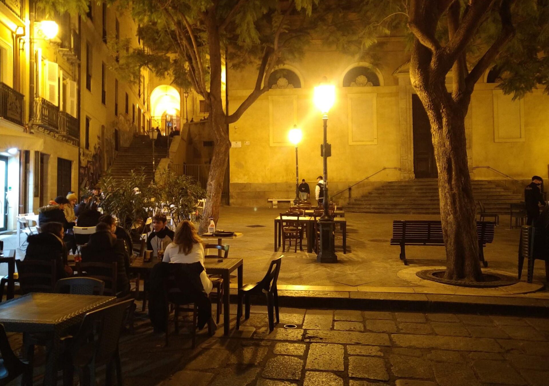 Piazza, notte, tavolini e persone